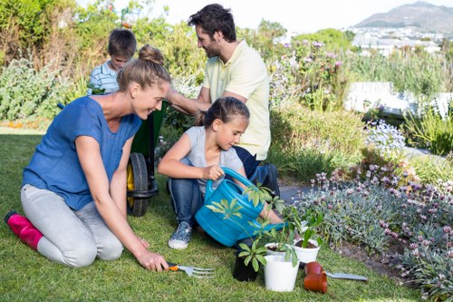 Professionals using hedge trimmers on a lush hedge